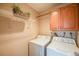 Efficient laundry room including washer, dryer, overhead shelving, and storage cabinets at 4400 S Quebec St # 107, Denver, CO 80237