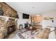 Open living room features stone fireplace, mounted TV, and dining area for easy entertaining at 4400 S Quebec St # 107, Denver, CO 80237