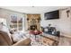 Cozy living room features stone fireplace, plush sofa, mounted TV, and balcony access at 4400 S Quebec St # 107, Denver, CO 80237