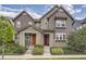 Two-story townhome with gray siding, red and orange doors, and landscaping at 8036 E 53Rd Dr, Denver, CO 80238