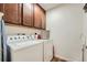 Bright laundry room with washer, dryer, and upper cabinets at 8036 E 53Rd Dr, Denver, CO 80238