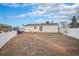 Backyard with a white fence, a shed, and a view of neighboring houses at 1683 Monroe St, Strasburg, CO 80136