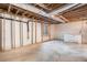 Unfinished basement with concrete floor, window and exposed ceiling at 1683 Monroe St, Strasburg, CO 80136