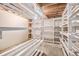 Unfinished basement with concrete floor and wooden shelves at 1683 Monroe St, Strasburg, CO 80136