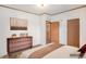 Nicely staged bedroom with hardwood floor, dresser, bed and doorway at 1683 Monroe St, Strasburg, CO 80136