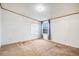 An empty bedroom featuring neutral carpet, white walls, and two windows with blue curtains at 1683 Monroe St, Strasburg, CO 80136