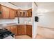 Classic kitchen with wood cabinets, linoleum flooring, and view to the adjacent living room at 1683 Monroe St, Strasburg, CO 80136