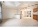 Spacious living room with neutral carpet, bright natural light, and access to kitchen at 1683 Monroe St, Strasburg, CO 80136