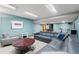 The basement features a large TV, multiple seating options, side tables, a lounge, and a painting at 2687 E 124Th Pl, Thornton, CO 80241