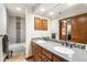 Bathroom featuring dual sinks, modern fixtures, granite countertops, and a shower with a tub at 2687 E 124Th Pl, Thornton, CO 80241