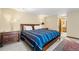 Cozy bedroom features a wood-framed bed with striped blanket, wood bedside tables and walk-in closet access at 2687 E 124Th Pl, Thornton, CO 80241