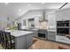 Bright, spacious kitchen with gray cabinetry, stainless steel appliances, and quartz countertops and hardwood flooring at 2687 E 124Th Pl, Thornton, CO 80241