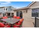 Outdoor patio featuring a dining table set, brick house exterior, and sliding glass doors to the home at 2687 E 124Th Pl, Thornton, CO 80241