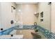 Updated shower featuring tile surround with glass door, seat, showerhead and toiletry niche at 2687 E 124Th Pl, Thornton, CO 80241