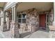 Charming front porch features brick pillars, a chair and the entry door at 157 Sand Cherry St, Brighton, CO 80601