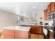 Spacious kitchen with an island, stainless steel microwave, black appliances, and hardwood floors at 157 Sand Cherry St, Brighton, CO 80601