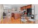 Eat-in kitchen featuring wood cabinets, an island, and easy access to the living room at 157 Sand Cherry St, Brighton, CO 80601