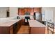 Well-lit kitchen features wood cabinets, black appliances, island, and hardwood floors at 157 Sand Cherry St, Brighton, CO 80601