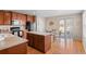 Eat-in kitchen featuring wood cabinets, an island, and easy access to the backyard at 157 Sand Cherry St, Brighton, CO 80601