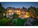 Expansive backyard with lush lawn, a stone fire pit, and beautiful landscaping at 5 Walden Ln, Cherry Hills Village, CO 80121