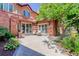 Charming outdoor patio featuring a brick facade, comfortable seating, and lush landscaping, perfect for relaxing outdoors at 5 Walden Ln, Cherry Hills Village, CO 80121