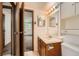 Bathroom with a single sink vanity, medicine cabinets, and an open view to the bedroom at 17381 E Mansfield Ave # 711L, Aurora, CO 80013