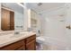 Bright bathroom featuring a single sink vanity, tiled shower-tub combo and overhead storage at 17381 E Mansfield Ave # 711L, Aurora, CO 80013