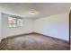 Spacious carpeted bedroom featuring a sun-filled window, radiator, and ample square footage for relaxation and personalization at 17381 E Mansfield Ave # 711L, Aurora, CO 80013