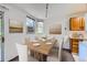 Bright dining room featuring a wood table, comfortable chairs, natural light, and an adjacent kitchen space at 17381 E Mansfield Ave # 711L, Aurora, CO 80013
