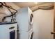 Efficient laundry area with stacked washer and dryer and a newer water heater at 17381 E Mansfield Ave # 711L, Aurora, CO 80013