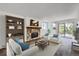 Inviting living room with a stone fireplace, light colored furniture, and sliding doors to the outside at 17381 E Mansfield Ave # 711L, Aurora, CO 80013