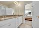 Bathroom with double sinks, white cabinets, and a doorway to bedroom at 18059 French Creek Ave, Parker, CO 80134