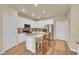 Modern kitchen with white cabinets, stainless steel appliances, a center island, and wood-look floors at 18059 French Creek Ave, Parker, CO 80134