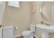 Bright powder room featuring a pedestal sink, framed artwork, and wood flooring at 18059 French Creek Ave, Parker, CO 80134