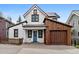 Charming two-story white home featuring a bright blue door and a rustic wooden garage at 208 N Ridge St, Breckenridge, CO 80424