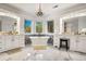 Bright bathroom featuring a soaking tub, marble floors, dual vanities, stylish lighting and large bay windows at 17820 Queensmere Dr, Monument, CO 80132