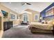 Beautiful bedroom featuring neutral walls, vaulted ceilings, a ceiling fan, a fireplace and large windows at 17820 Queensmere Dr, Monument, CO 80132