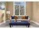 Bedroom sitting area features a white sofa with blue and gold pillows, and a blue tufted ottoman at 17820 Queensmere Dr, Monument, CO 80132