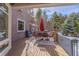 Outdoor deck with a dining area, grill, patio umbrella, and views of mature trees at 17820 Queensmere Dr, Monument, CO 80132