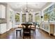 Sunlit dining area with a modern chandelier, vaulted ceilings, hardwood floors, and oversized windows at 17820 Queensmere Dr, Monument, CO 80132