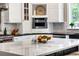 Close up view of the kitchen island featuring white marble counters and a stylish gourmet kitchen with stainless steel appliances at 17820 Queensmere Dr, Monument, CO 80132