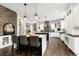 A full kitchen view with a large island, marble countertops, pendant lighting, stainless steel appliances, and hardwood floors at 17820 Queensmere Dr, Monument, CO 80132