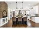 An open kitchen features a large marble island, pendant lighting, stainless steel appliances, and hardwood flooring at 17820 Queensmere Dr, Monument, CO 80132