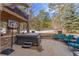 A covered patio with a hot tub, basketball hoop, and comfortable seating area for relaxing and enjoying the outdoors at 17820 Queensmere Dr, Monument, CO 80132