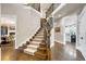 Elegant staircase with carpeted steps, wood railing with iron spindles and wood floors at 17820 Queensmere Dr, Monument, CO 80132