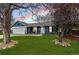 Charming blue home featuring a well-manicured lawn, and a cozy front porch with decorative trees at 20908 E Dorado Cir, Centennial, CO 80015