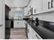 Modern kitchen features white cabinets, black countertops, stainless steel appliances, and stylish hardware at 20908 E Dorado Cir, Centennial, CO 80015