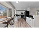 Modern kitchen featuring bar seating, stainless appliances, sleek black countertops, and white cabinetry at 20908 E Dorado Cir, Centennial, CO 80015