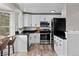Modern kitchen featuring white cabinets, stainless steel appliances, black countertops, and wood-look flooring at 20908 E Dorado Cir, Centennial, CO 80015