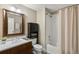Bathroom with wood vanity, framed mirror, and shower-tub combo at 1674 Fillmore St # Al3, Denver, CO 80206